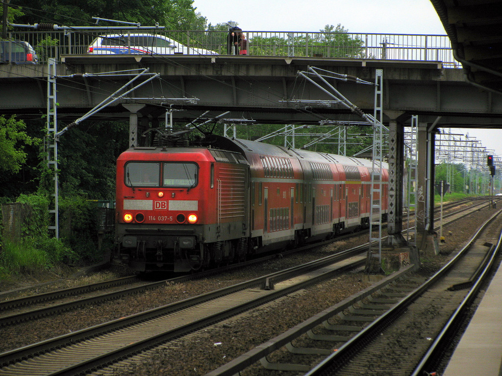 114 037-5 durcheilt mit einem RE 1 den Bahnhof Berlin Wuhlheide, w�hrend rechts bereit die S-Bahn einf�hrt konnte ich noch schnell dn RE 1 festhalten. 12.06.2010