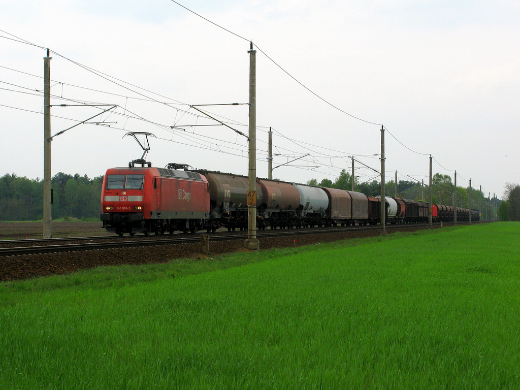 145 010-5 passiert mit einem f�r die Fotostelle sch�nen G�terzug den Bahn�berweg L�pten mit 70 km/h. Am Umleiterwochenende 1./2.Mai 2010 war eine Menge los!