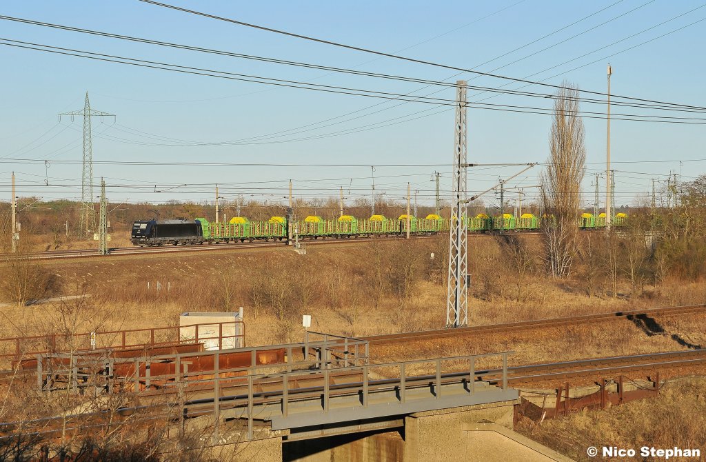 185 547-7 der Press mit einem vollen Holzzug nach Niederg�rne auf der NBS Berlin-Hannover im Kreuz von Wustermark (06.03.11)