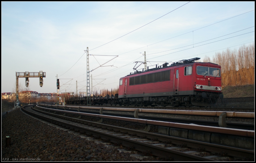 DB 155 262 mit Rungenwagen (gesehen Berlin Bornholmer Stra�e/Nordkreuz 21.03.2011 - Fotografiert vom Fu�weg neben dem Bahndamm)
