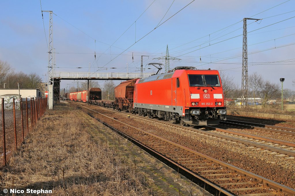 Die frisch gewaschene 185 352-2 f�hrt mit einem gemischten Zug unter der Fu�g�ngerbr�cke von Saarmund durch (09.02.11)