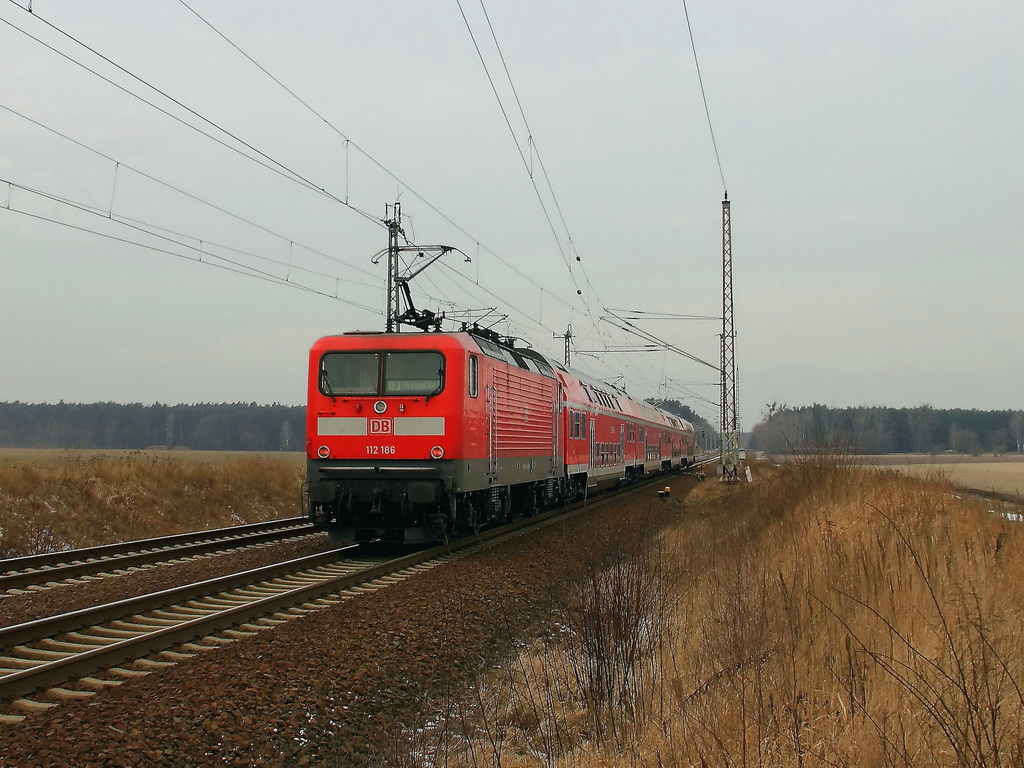 Schublok 112 186 mit dem RE 3 nach Stralsund am 07. Februar 2012 nach dem passieren des Bahn�bergang �ber die Bundesstrasse 96 / 115 in Gol�en in Richtung Berlin. 