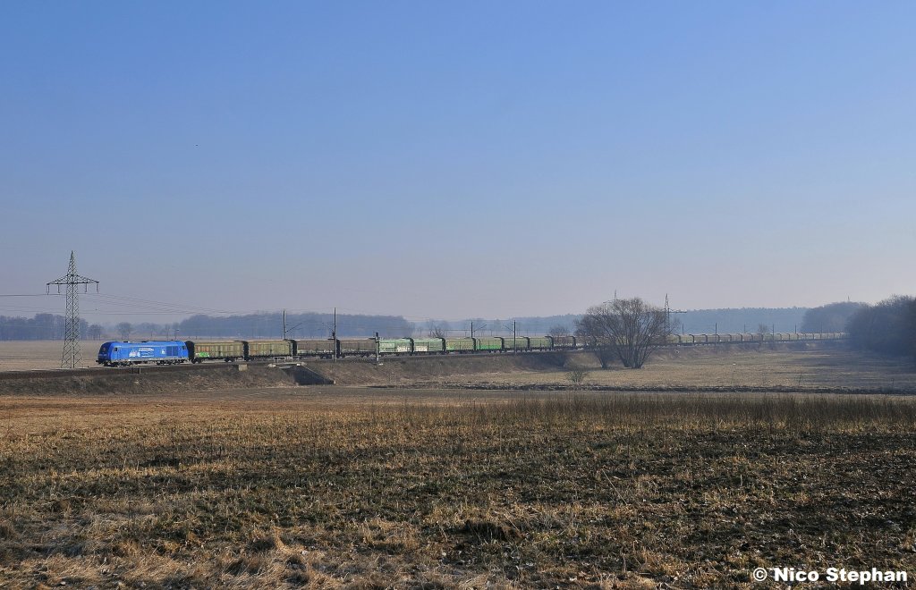 Was blaues! Die 253 014-9 mit einem Hackschnitzelzug gen Westen,hier brummt sie am �rtchen Nudow vorbei (03.03.11)